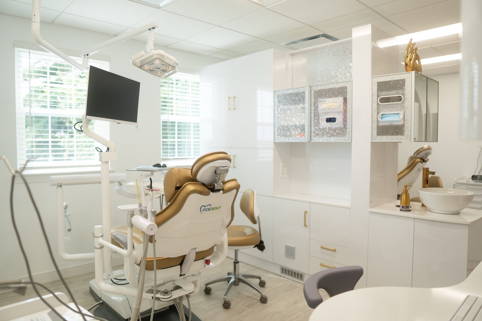 A treatment room at the Alexandria office with a gold and cream dental chair beside the window