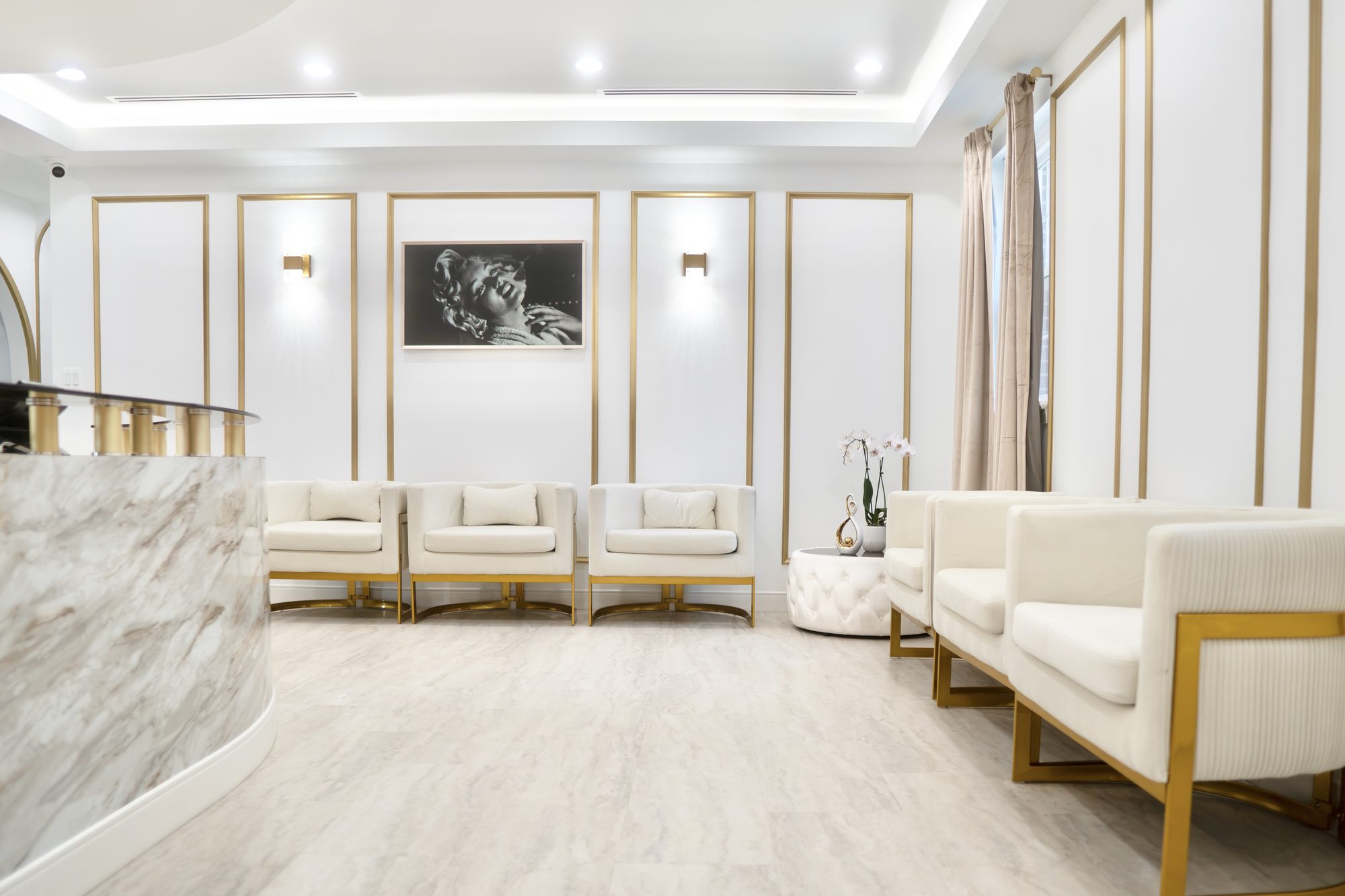 The waiting area at Dr. Nahlah's Alexandria office, cream and gold chairs along gold-framed panels